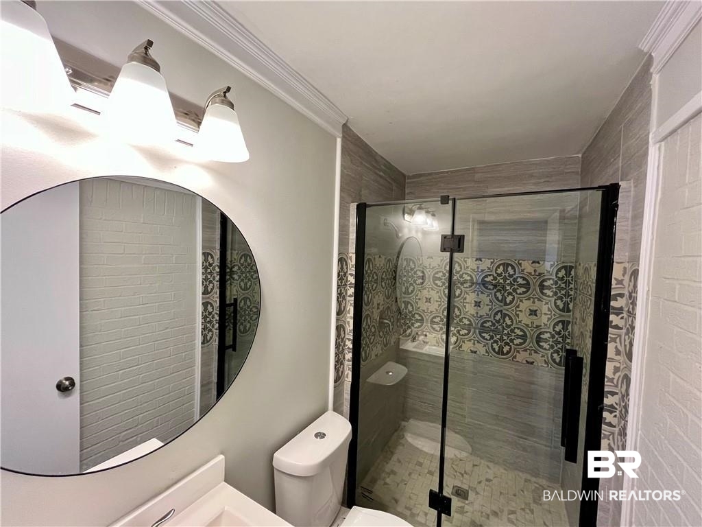 8636 Boe Road Irvington, AL 36544 - Photo 12 of 22 Bathroom with vanity, a stall shower, and ornamental molding
