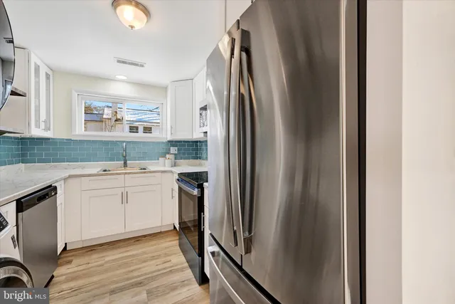 a kitchen with a sink cabinets and stainless steel appliances