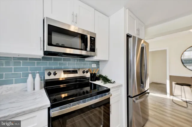 a kitchen with stainless steel appliances a stove a microwave and a refrigerator