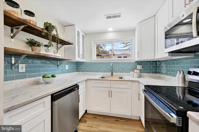 a kitchen with a sink a stove and cabinets