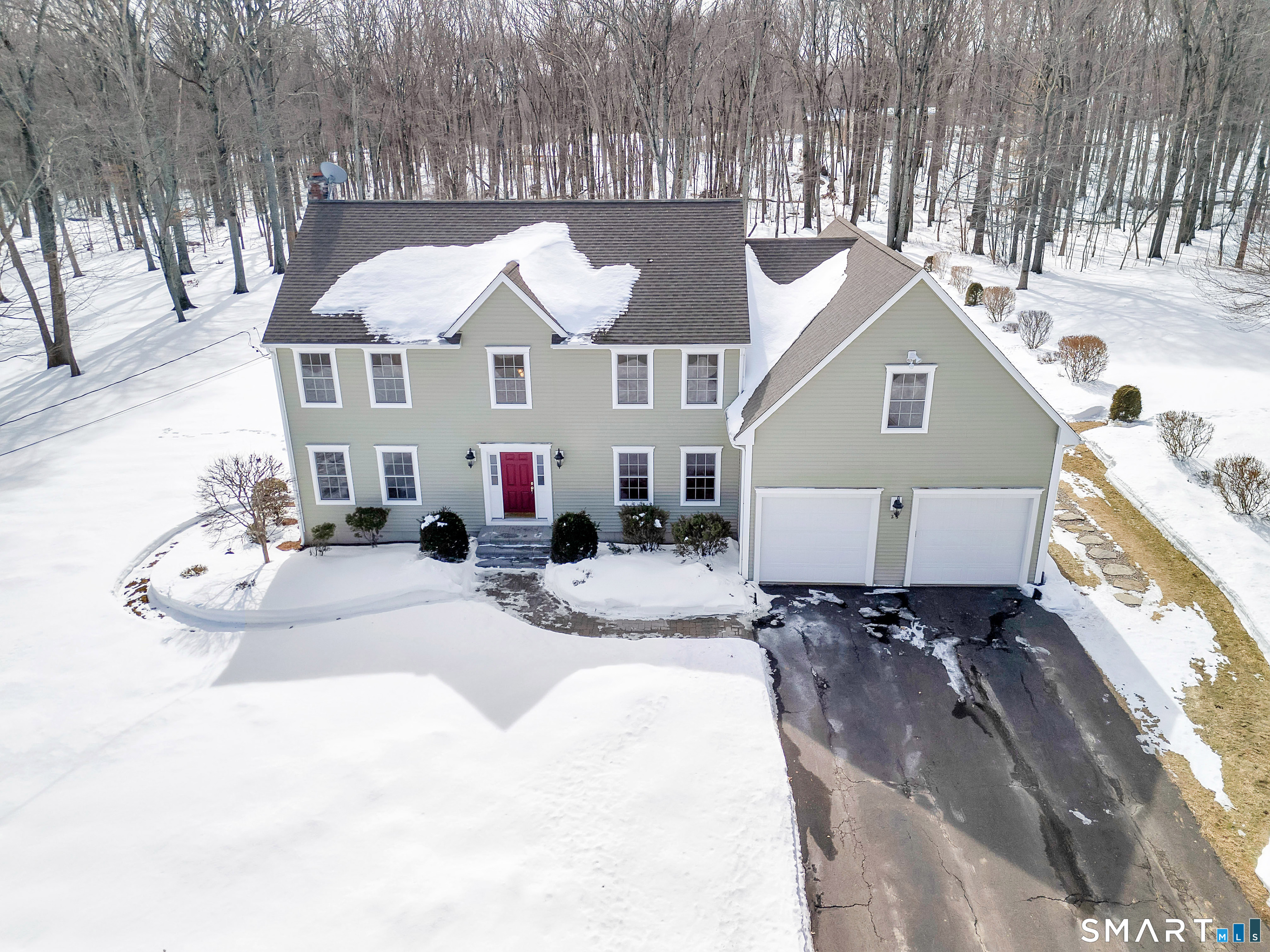 a view of a white house with a yard covered in snow