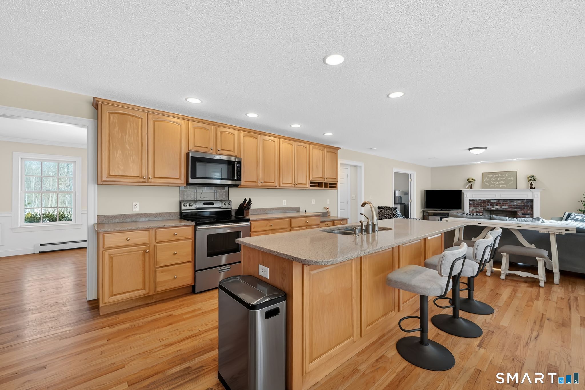 23 Neville Street Coventry, CT 06238 - Photo 4 of 40 a kitchen with stainless steel appliances granite countertop a stove top oven a sink dishwasher a dining table and chairs with wooden floor