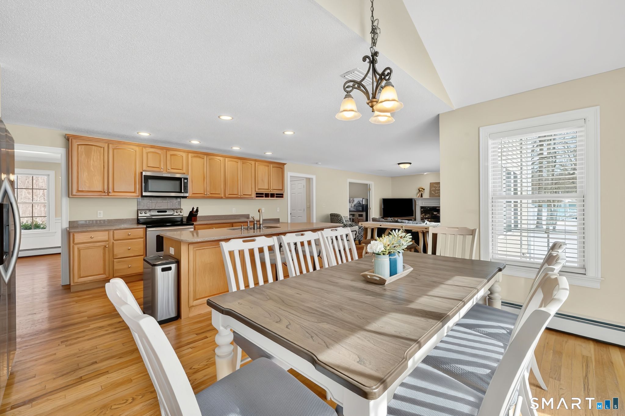 23 Neville Street Coventry, CT 06238 - Photo 5 of 40 a kitchen with stainless steel appliances granite countertop a stove top oven a sink dishwasher a dining table and chairs with wooden floor
