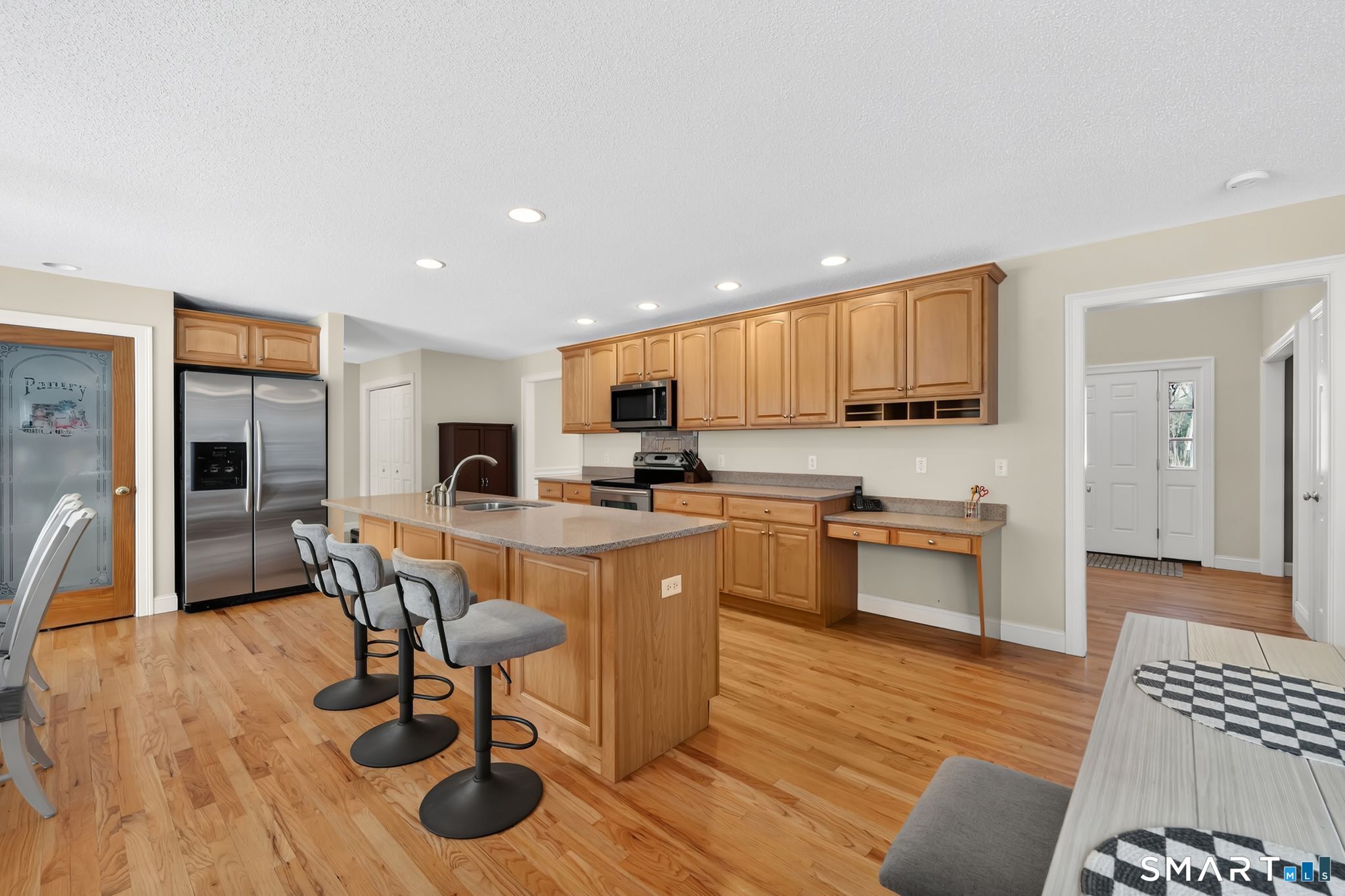 23 Neville Street Coventry, CT 06238 - Photo 7 of 40 a kitchen with stainless steel appliances granite countertop a refrigerator a stove a sink a dining table and chairs with wooden floor