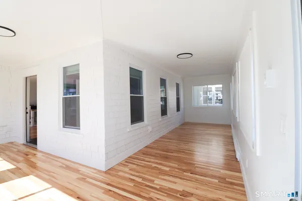 a view of a livingroom with wooden floor and windows