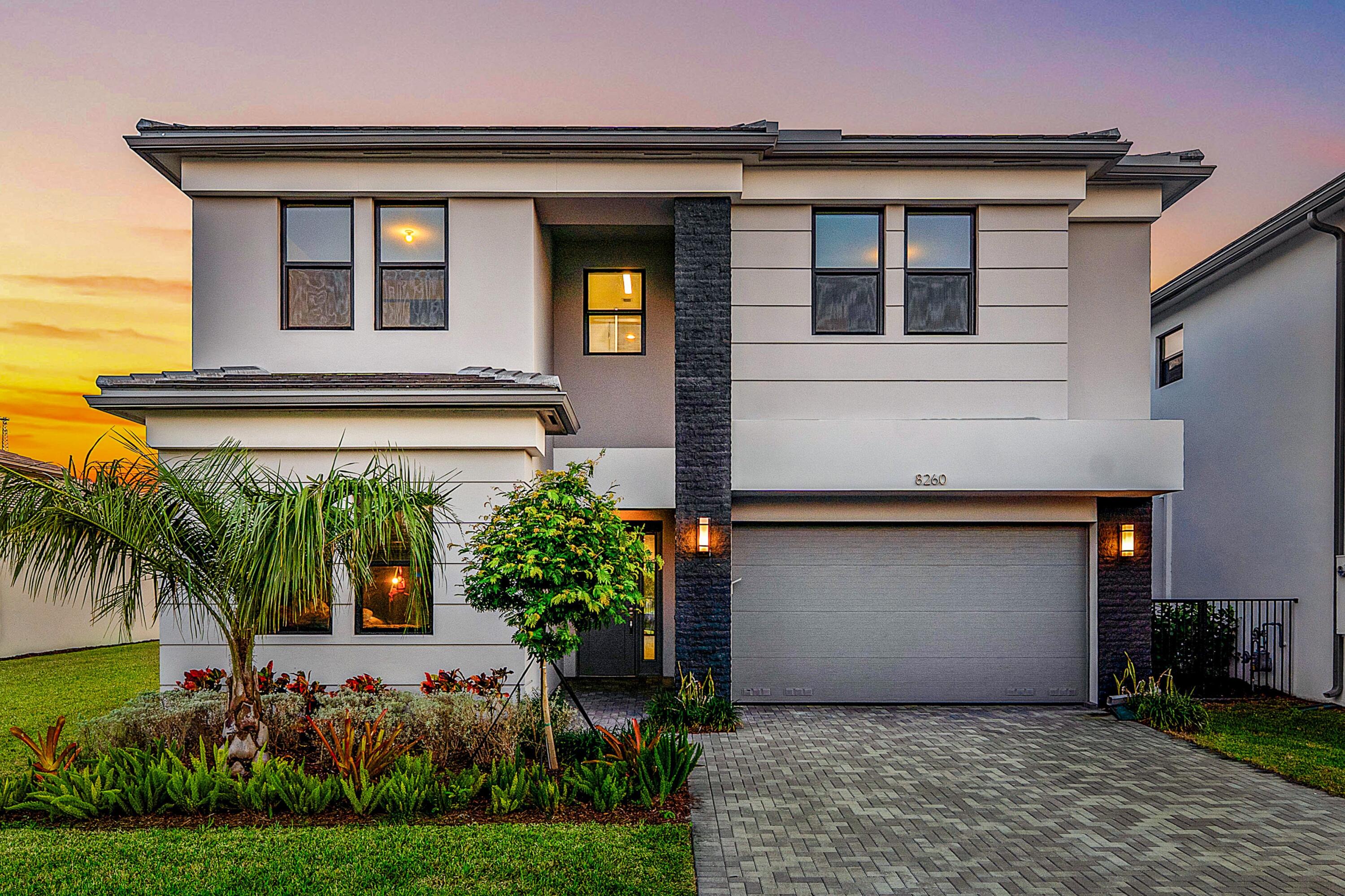 a front view of a house with a yard and potted plants