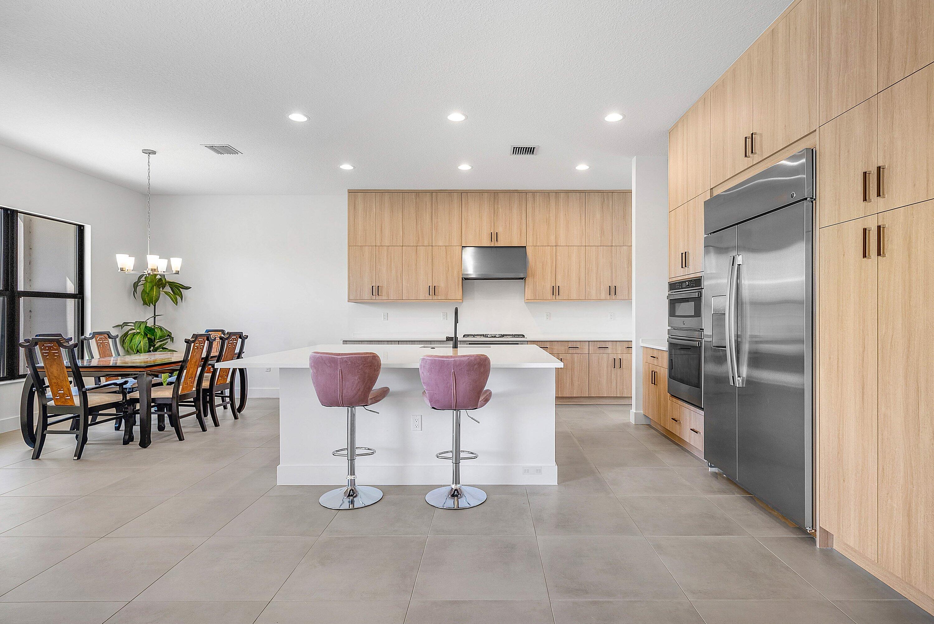 8260 Royal County Down Road Boca Raton, FL 33434 - Photo 16 of 115 a kitchen with stainless steel appliances kitchen island granite countertop a table and chairs in it