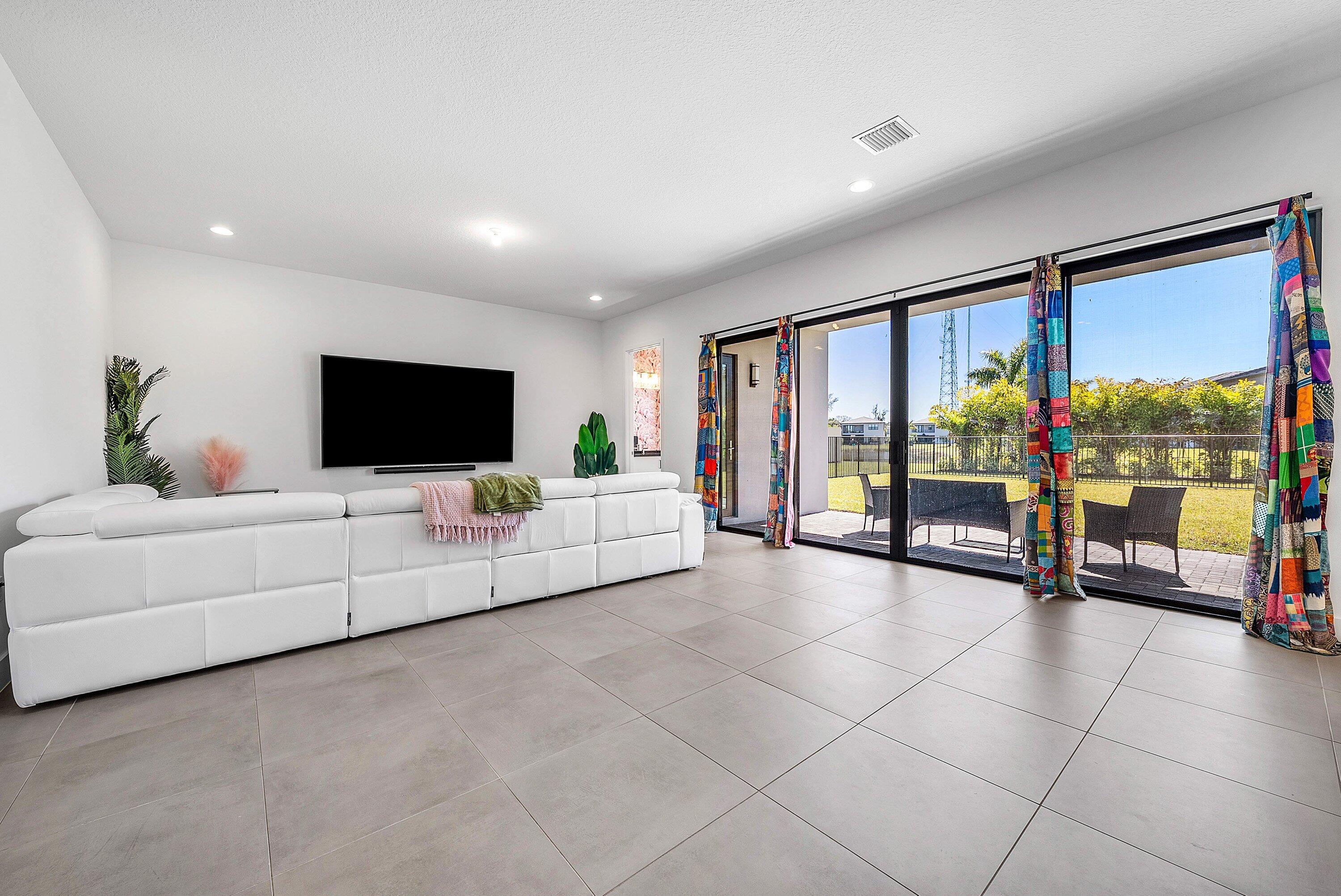 8260 Royal County Down Road Boca Raton, FL 33434 - Photo 28 of 115 a living room with furniture and a flat screen tv