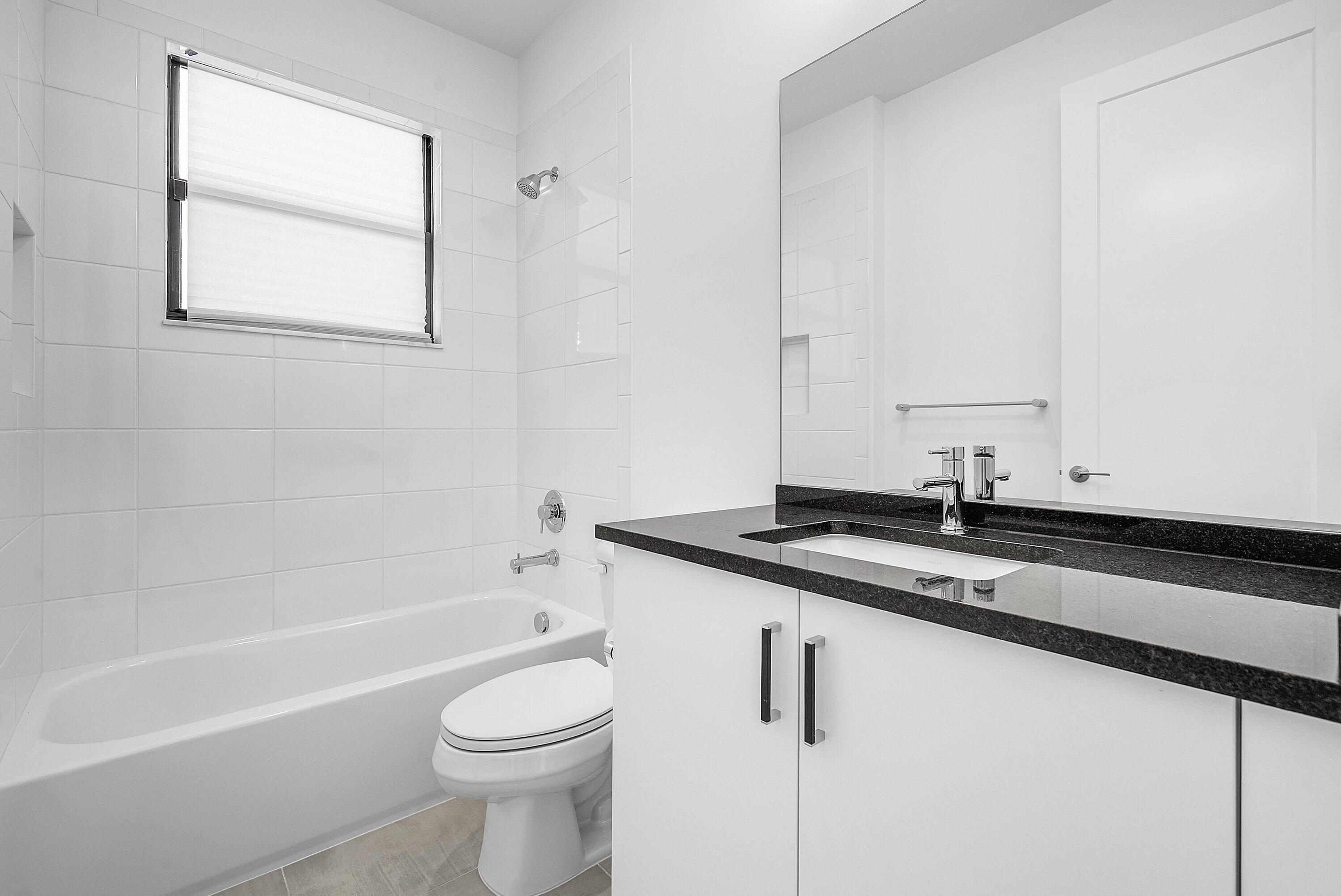 8260 Royal County Down Road Boca Raton, FL 33434 - Photo 33 of 115 a bathroom with a granite countertop sink a toilet and bathtub
