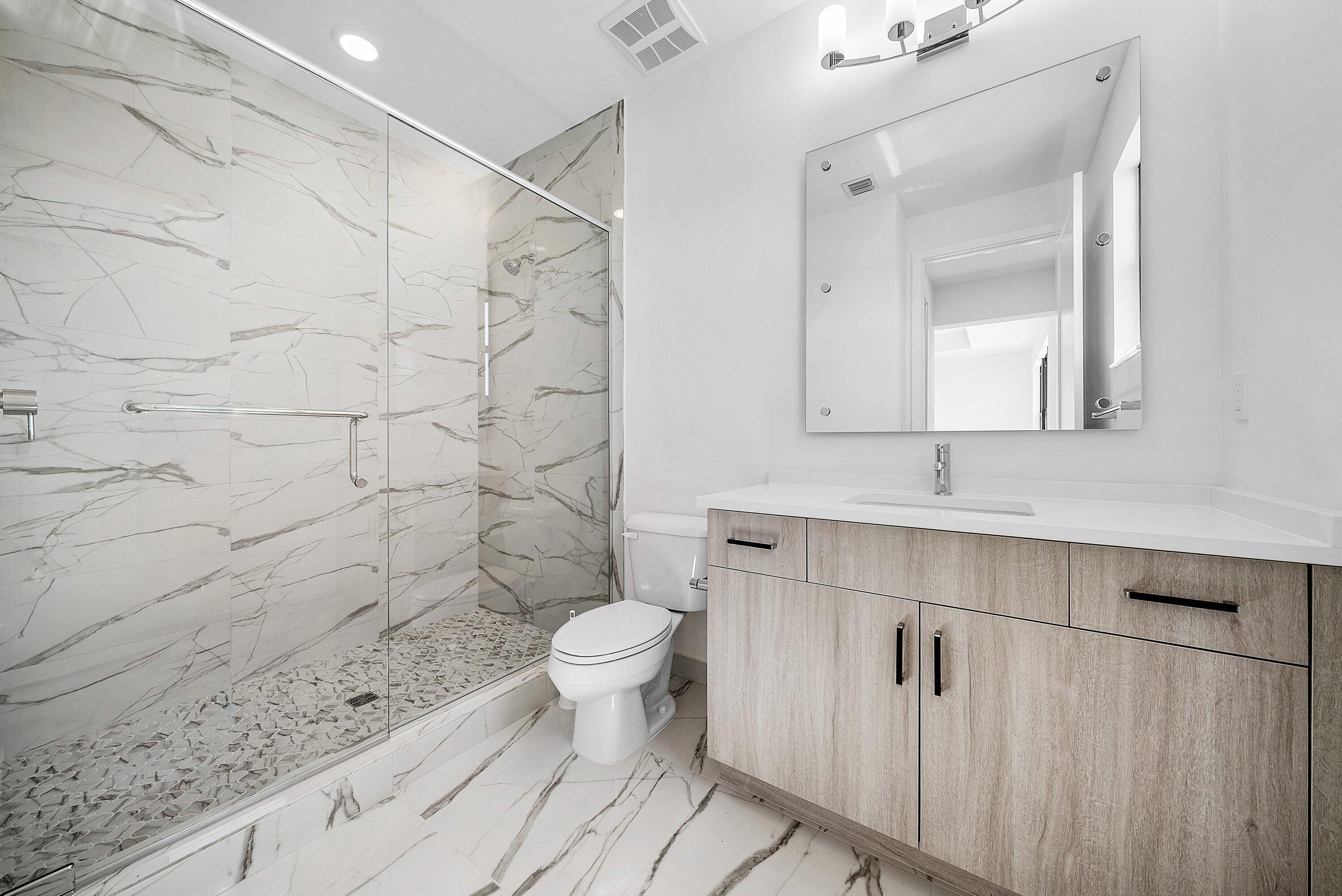 8260 Royal County Down Road Boca Raton, FL 33434 - Photo 47 of 115 a bathroom with a sink a toilet and a mirror