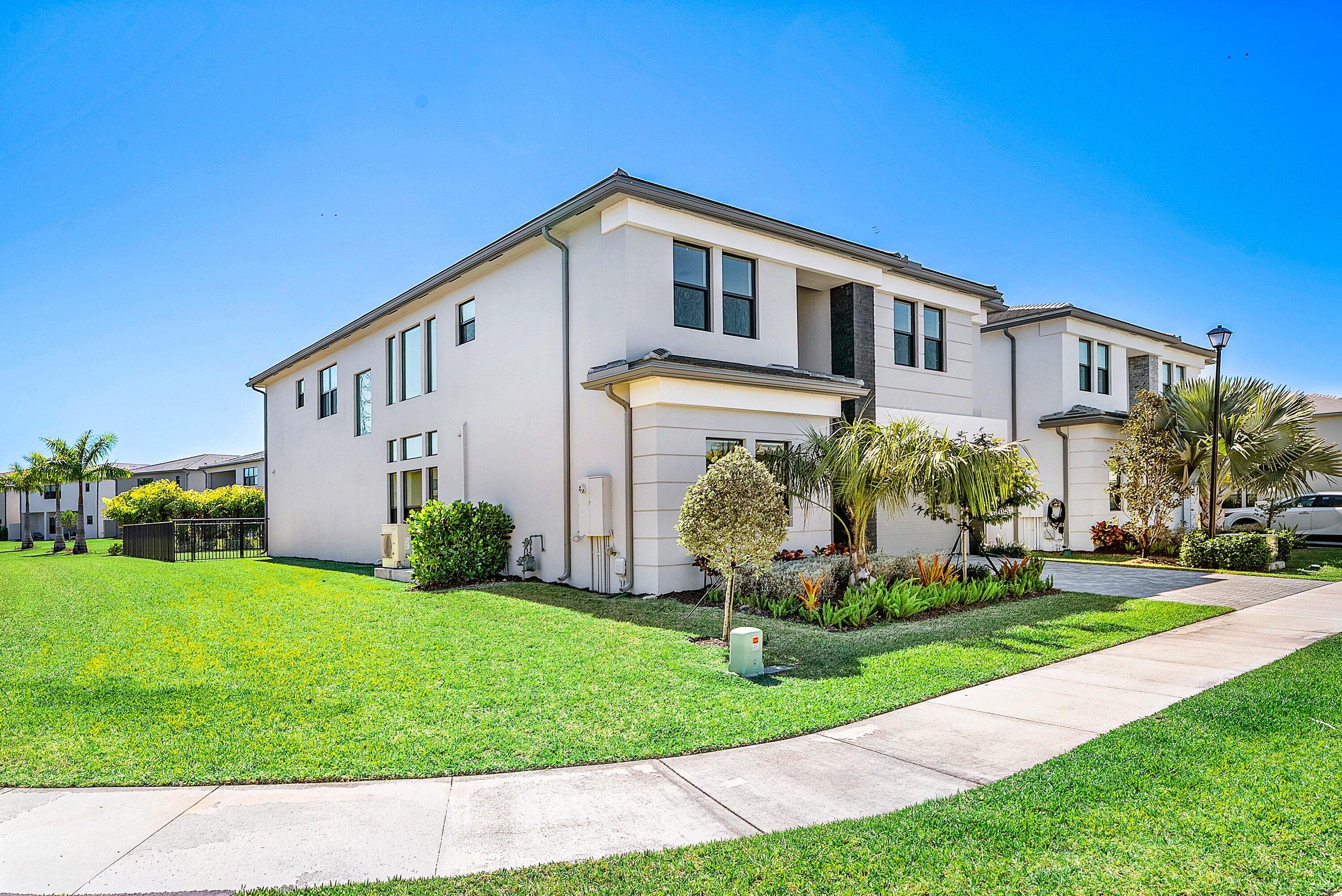 8260 Royal County Down Road Boca Raton, FL 33434 - Photo 6 of 115 a front view of a house with a yard