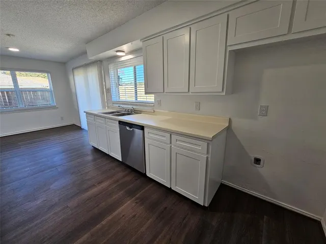 a kitchen with a sink cabinets and wooden floor