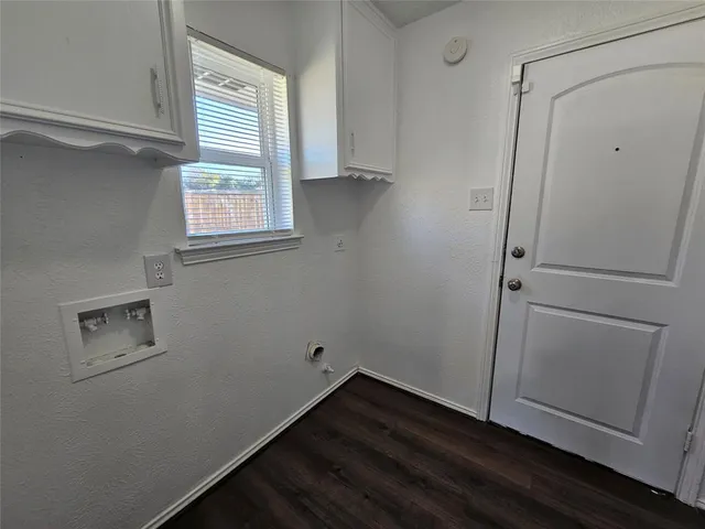 a view of storage and utility room with wooden floor and window