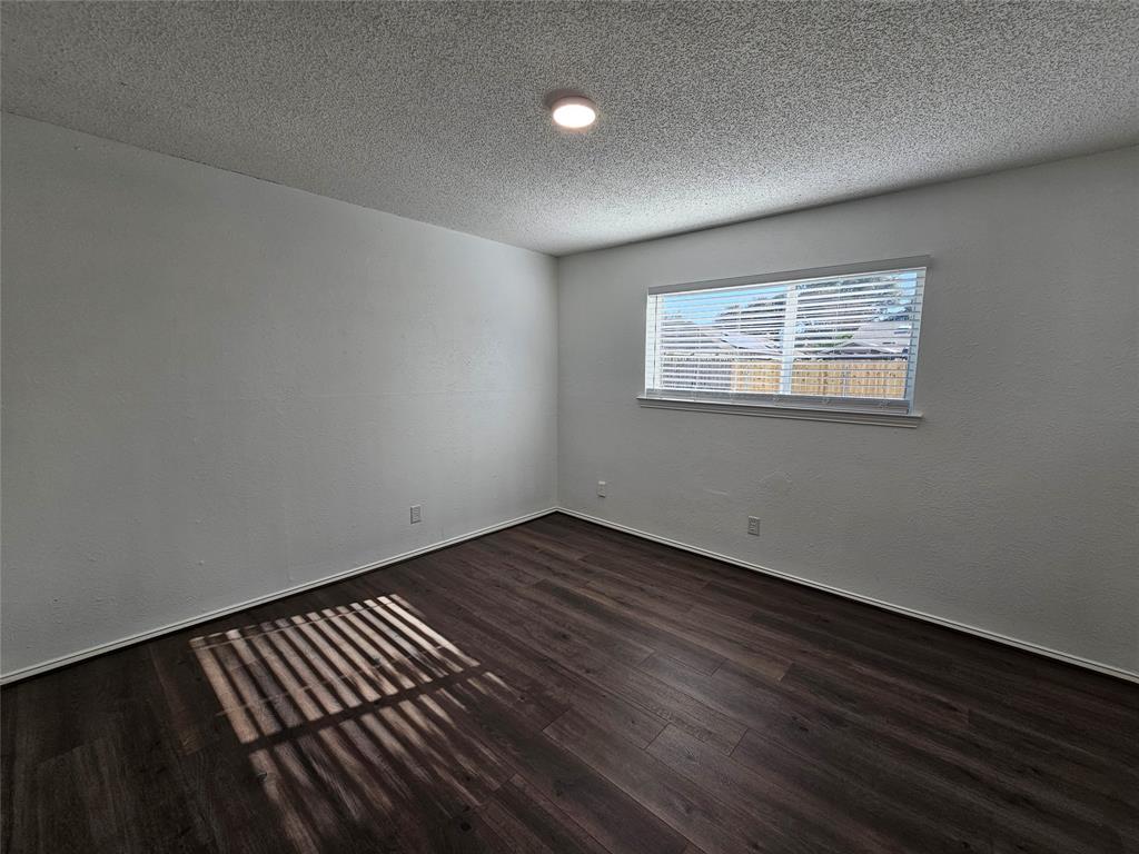 2400 Meadow Creek Drive Carrollton, TX 75006 - Photo 20 of 33 an empty room with wooden floor and windows