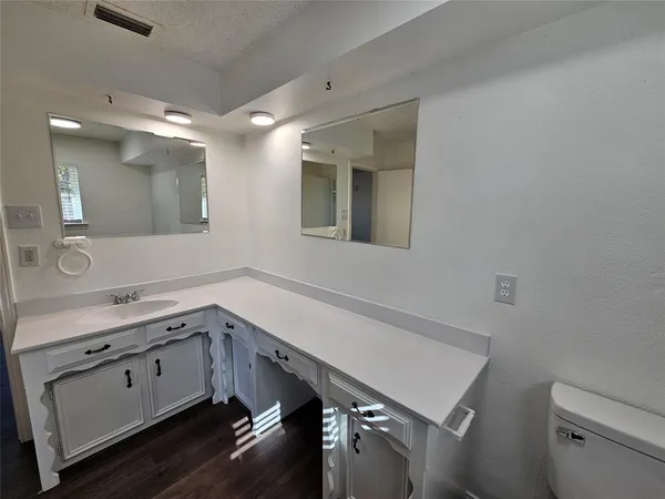a room with a sink cabinets and wooden floor