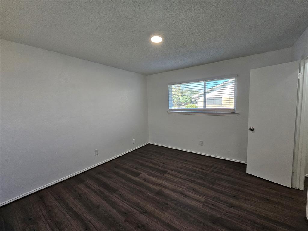 2400 Meadow Creek Drive Carrollton, TX 75006 - Photo 26 of 33 an empty room with wooden floor and windows