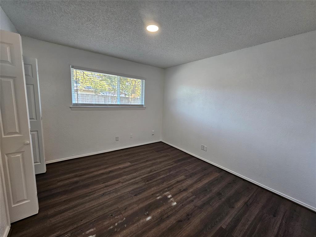 2400 Meadow Creek Drive Carrollton, TX 75006 - Photo 28 of 33 an empty room with wooden floor and windows
