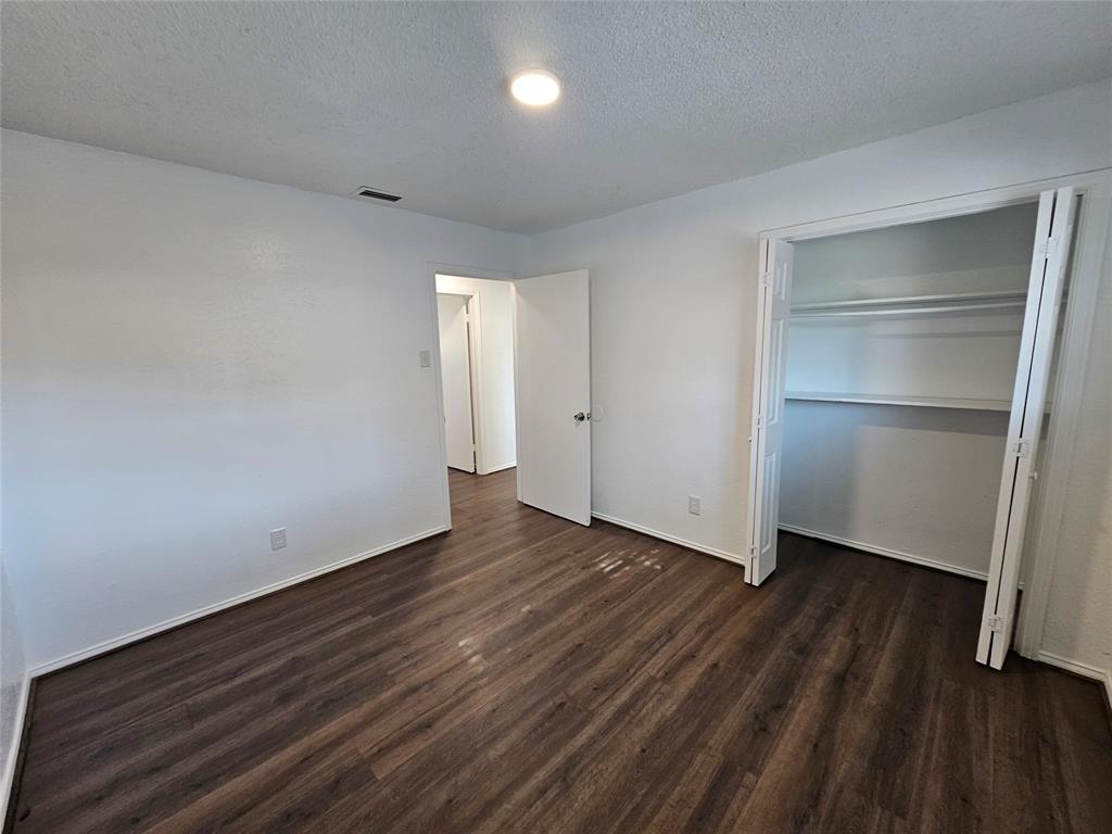 2400 Meadow Creek Drive Carrollton, TX 75006 - Photo 29 of 33 a view of an empty room with wooden floor & closet