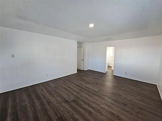 a view of an empty room and wooden floor