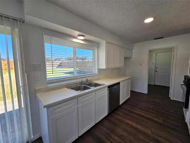 a kitchen with a sink stove and cabinets