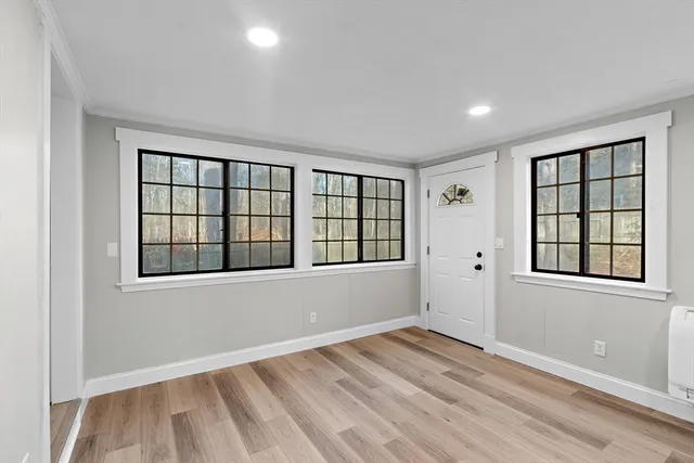 an empty room with wooden floor and windows