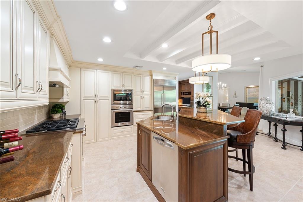 809 Buttonbush Lane Naples, FL 34108 - Photo 7 of 23 a kitchen with stainless steel appliances kitchen island granite countertop a sink a stove a refrigerator and chairs