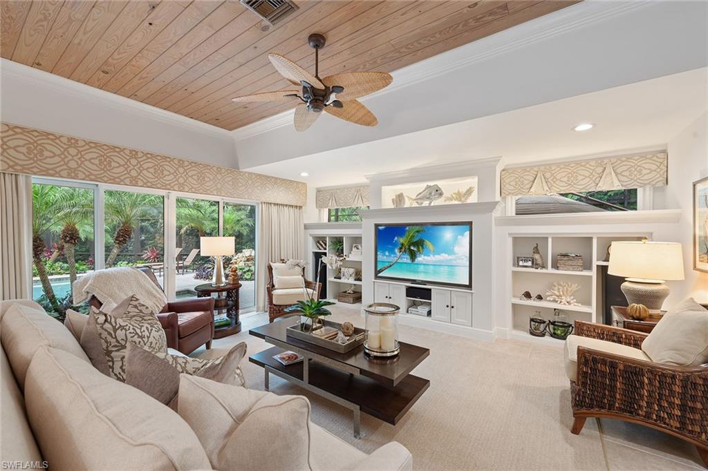 809 Buttonbush Lane Naples, FL 34108 - Photo 8 of 23 a living room with furniture flat screen tv and a large window
