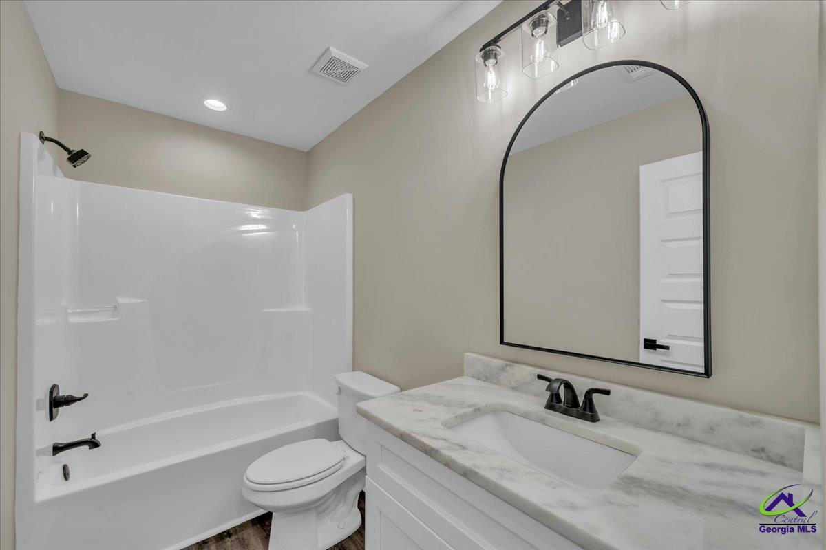 103 Early Drive Byron, GA 31008 - Photo 40 of 56 a bathroom with a granite countertop sink a toilet and a mirror