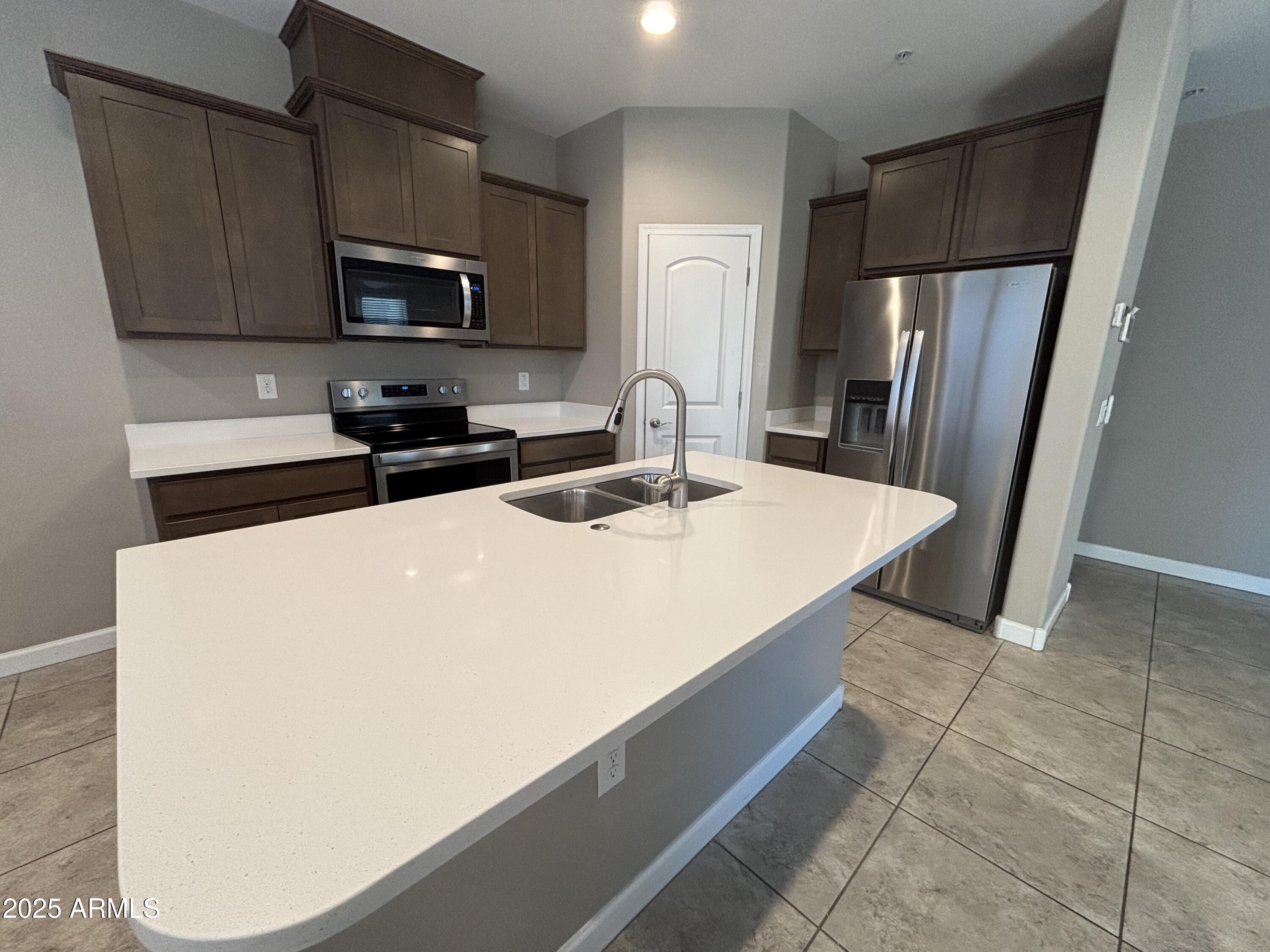 1255 North Arizona Avenue, Unit 1124 Chandler, AZ 85225 - Photo 4 of 29 a kitchen with stainless steel appliances a refrigerator sink and microwave