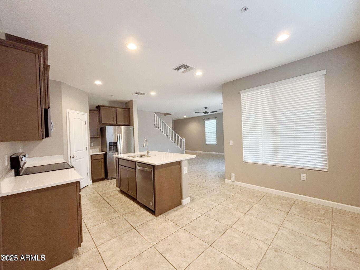 1255 North Arizona Avenue, Unit 1124 Chandler, AZ 85225 - Photo 5 of 29 a large kitchen with kitchen island granite countertop a sink and a stove top oven with wooden floor