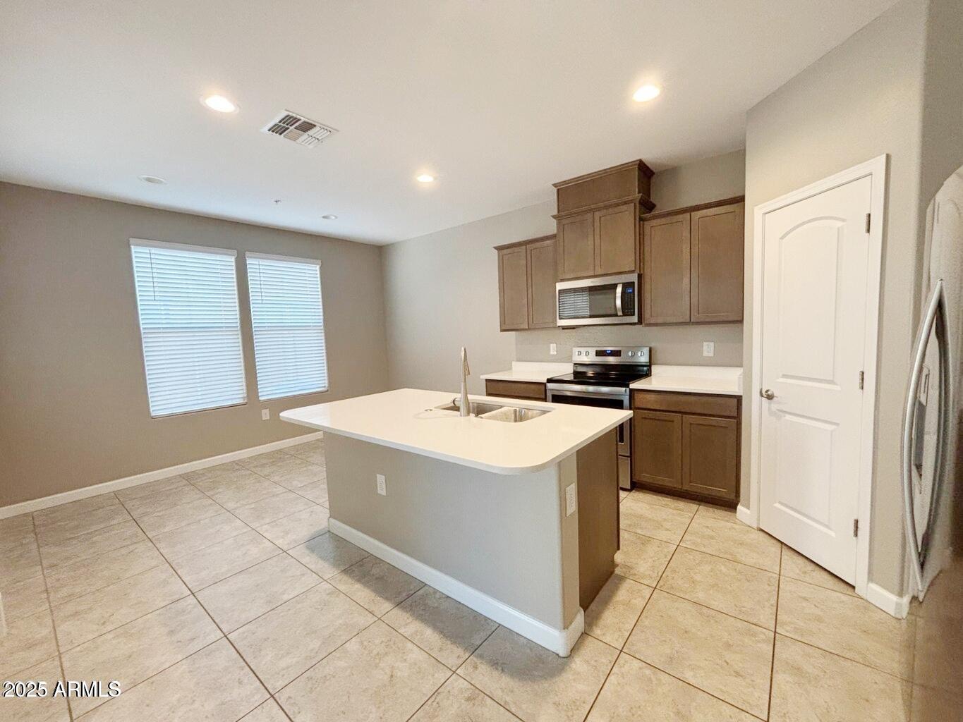 1255 North Arizona Avenue, Unit 1124 Chandler, AZ 85225 - Photo 7 of 29 a kitchen with stainless steel appliances granite countertop a stove and a refrigerator