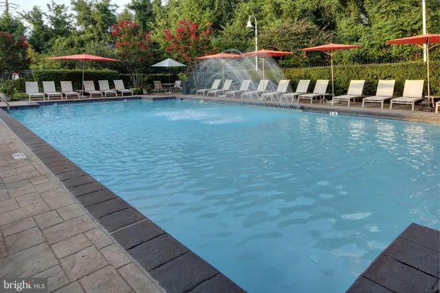 a view of a swimming pool with lawn chairs under an umbrella