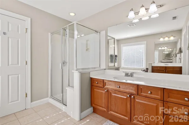 a spacious bathroom with a granite countertop sink a mirror and a shower