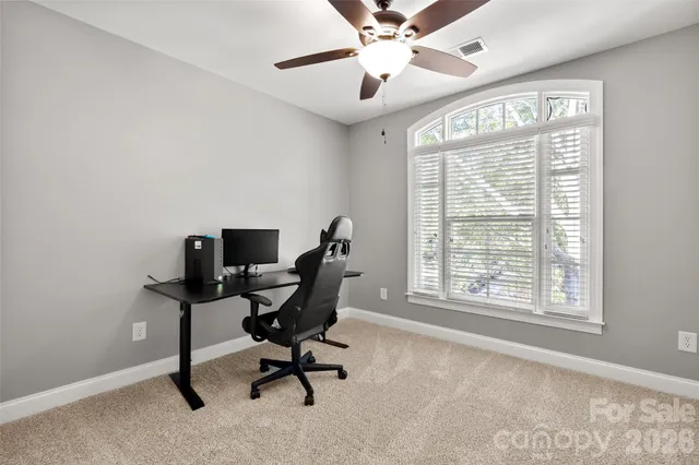 a view of a workspace with furniture and a window