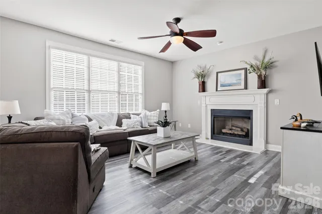 a living room with furniture ceiling fan and a fireplace