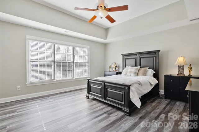 a spacious bedroom with a bed a chandelier and a window