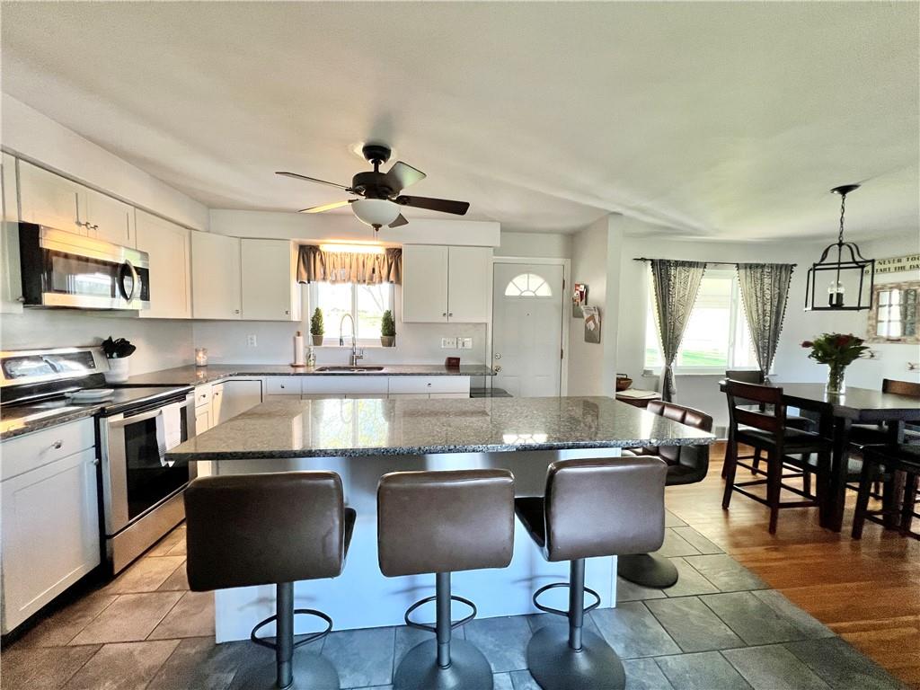 2175 Frew Mill Road New Castle, PA 16101 - Photo 11 of 25 a kitchen with stainless steel appliances granite countertop a stove a sink a stove a dining table and chairs