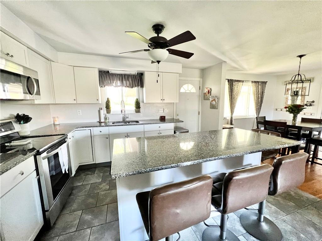 2175 Frew Mill Road New Castle, PA 16101 - Photo 14 of 25 a large kitchen with granite countertop lots of white cabinets stainless steel appliances dining table and chairs