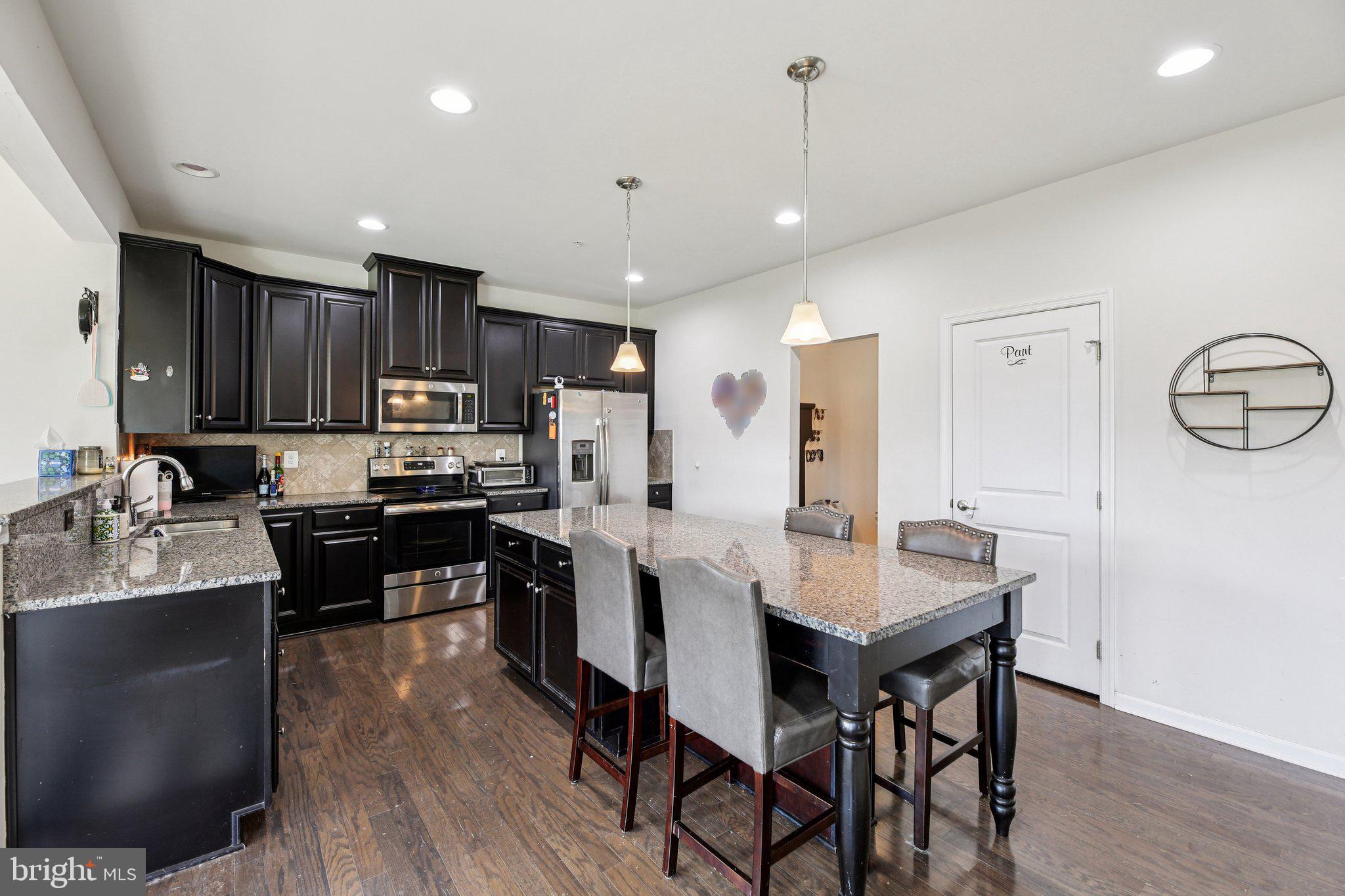 5733 Allender Road White Marsh, MD 21162 - Photo 11 of 47 a kitchen with kitchen island granite countertop a center island stainless steel appliances cabinets and a counter top space