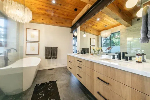 a large white tub sitting in a bathroom next to a bathroom sink