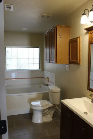a bathroom with a toilet a sink and a window