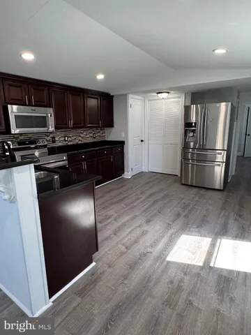 a kitchen with stainless steel appliances granite countertop a refrigerator a stove a sink and a microwave