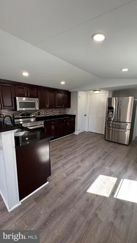 a kitchen with stainless steel appliances granite countertop a stove a refrigerator and a microwave