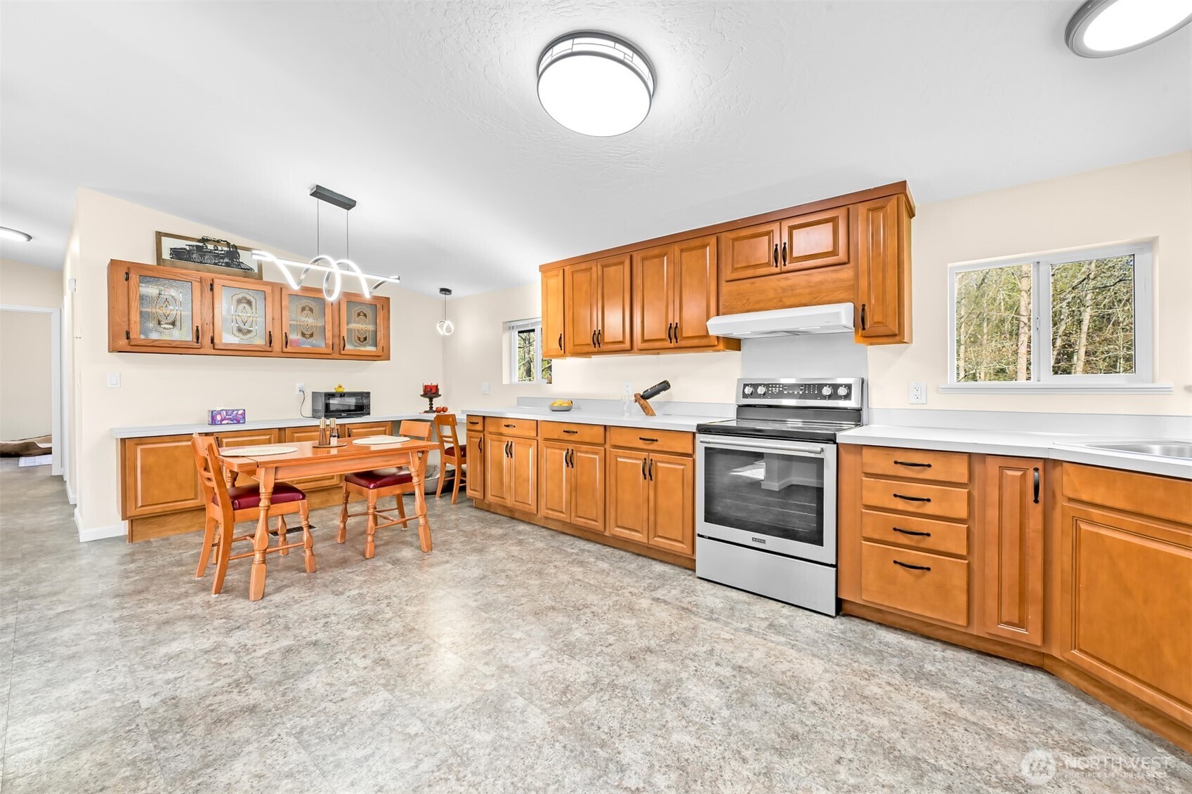 4930 Noon Road Bellingham, WA 98226 - Photo 8 of 27 a kitchen with stainless steel appliances kitchen island granite countertop a stove top oven a sink a dining table and chairs
