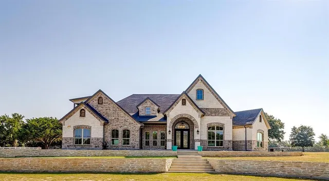a view of a house with a big yard and large trees
