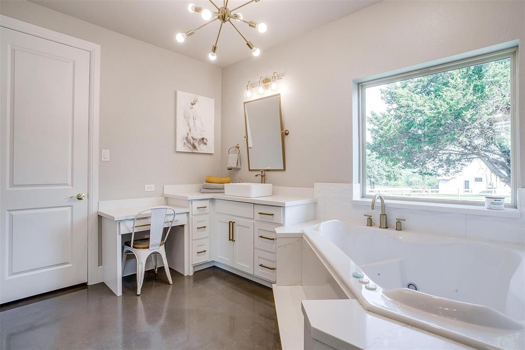 3207 Hummingbird Court Granbury, TX 76049 - Photo 19 of 40 a bathroom with a granite countertop sink mirror and a bathtub