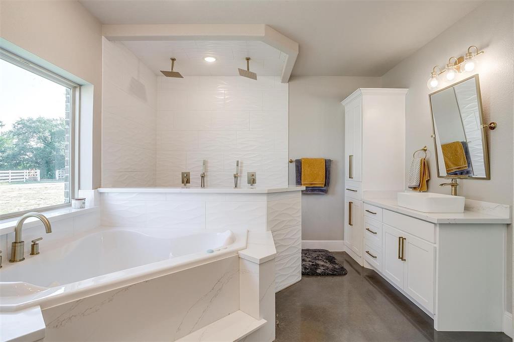 3207 Hummingbird Court Granbury, TX 76049 - Photo 22 of 40 a bathroom with a tub sink and mirror
