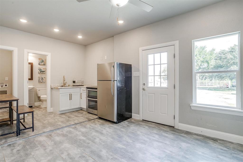3207 Hummingbird Court Granbury, TX 76049 - Photo 40 of 40 a view of a kitchen with refrigerator and wooden cabinets