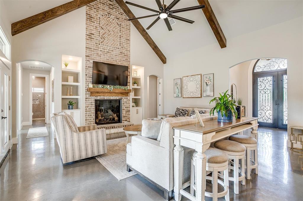 3207 Hummingbird Court Granbury, TX 76049 - Photo 5 of 40 a living room with furniture a flat screen tv and a fireplace