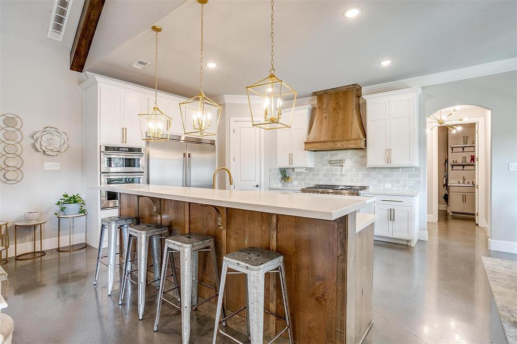 3207 Hummingbird Court Granbury, TX 76049 - Photo 7 of 40 a kitchen with stainless steel appliances kitchen island granite countertop a sink and cabinets